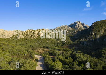 Vue de dessus, superbe vue aérienne de certaines montagnes de granit avec une route qui les traverse. Sardaigne, Italie. Banque D'Images