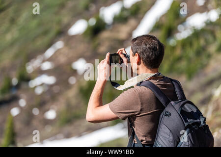 L'homme à prendre des photos de vue sur Linkins Lake Trail sur col de l'indépendance dans les montagnes Rocheuses près de Aspen, Colorado au début de l'été de 2019 avec la neige backg Banque D'Images