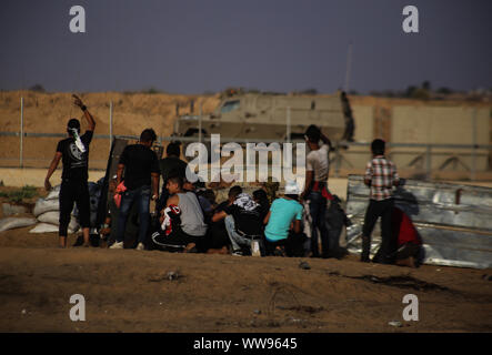 Gaza, la Palestine. 13 Sep, 2019. Des manifestants palestiniens se mettre à l'abri de forces de sécurité israéliennes au cours d'une manifestation anti-israélienne à la frontière Israel-Gaza clôture dans le sud de la bande de Gaza. Credit : SOPA/Alamy Images Limited Live News Banque D'Images