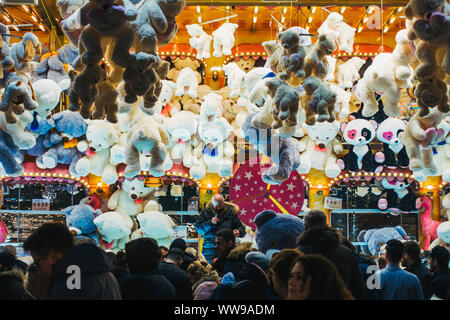 Des dizaines d'animaux en peluche suspendu au-dessus d'un tirage au sort-comme le jeu tandis que les participants à pied, juste passé une nuit dans un champ de foire à Hambourg, Allemagne Banque D'Images