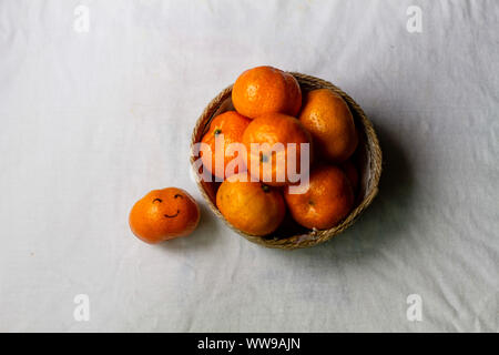 Vue aérienne d'un panier rempli d'oranges clémentines montrant le concept de l'été, un mode de vie sain et durable et le bien-être Banque D'Images