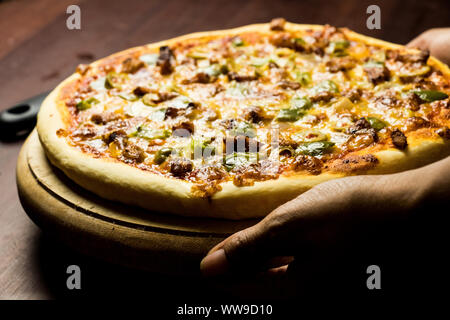 Pan Pizza prendre d'un côté libre de tenir la main Banque D'Images