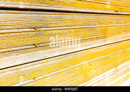 Les vieux panneaux en bois avec des fissures comme arrière-plan. Des planches de texture avec la peinture jaune minable Banque D'Images