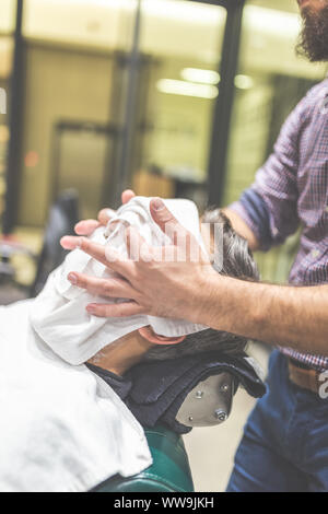 Coiffure homme visage pour préparer le rasage d'une serviette chaude dans barber shop Banque D'Images