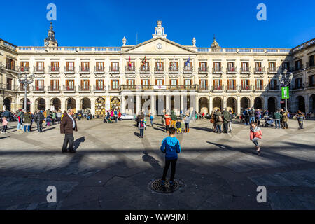 Les personnes bénéficiant d'une journée ensoleillée en face de Vitoria Gasteiz mairie à Plaza Nueva. Vitoria-Gasteiz, Pays Basque, Espagne, janvier 2019 Banque D'Images