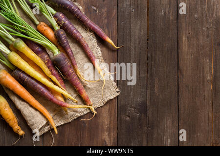 Produits frais bio carottes arc-en-ciel sur une table en bois Banque D'Images