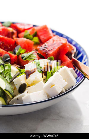 Le curcuma colorés salade de pastèque pois chiche fromage, tomates, les courgettes, la menthe et le vinaigre balsamique sur table de marbre. Fraîcheur d'été déjeuner facile Banque D'Images