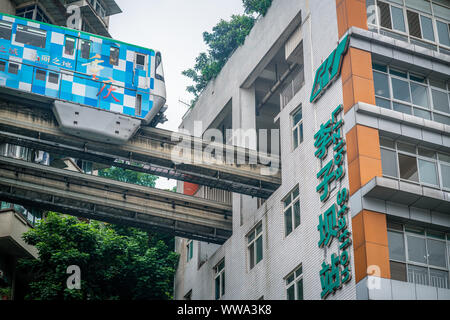 Chongqing, Chine, le 7 août 2019 : près de Chongqing metro train sur le point d'entrer dans la station Liziba célèbre pour être à l'intérieur d'un bâtiment résidentiel je Banque D'Images