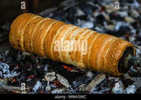 Préparation de la célèbre, traditionnels et délicieux gâteau cheminée hongrois Kurtos Kürtőskalács (Kolacs) Banque D'Images