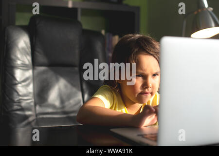 Cute baby girl travaillant sur un ordinateur à la maison. Banque D'Images