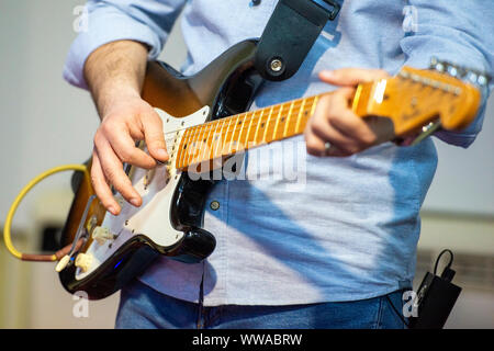 Jeune homme jouant sur une guitare électrique close up Banque D'Images