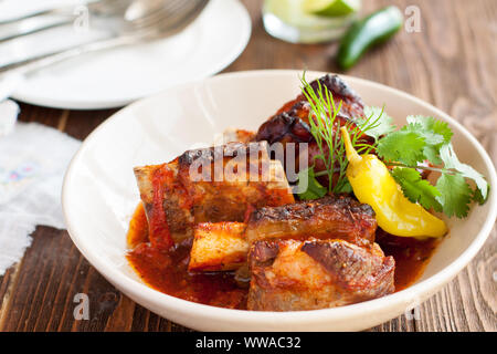 Boeuf braisé aux côtes courtes servi avec du piment jalapeno et herbes fraîches sur planche de bois Banque D'Images