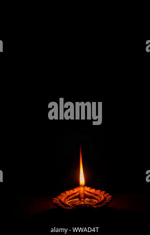 Happy Diwali - Diya lampe à pétrole allumée pendant la saison de fête de Diwali Indien avec copie espace dans le format portrait. Banque D'Images