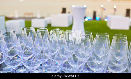 Un grand nombre de verres de vin dans une rangée. Lunettes de luxe pour l'alcool. Verres à vin avec du vin sur une table à l'extérieur. Banque D'Images