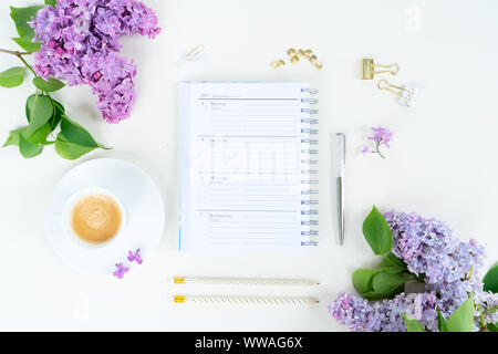 Télévision jeter Vue de dessus de l'espace de bureau à domicile - ordinateur portable avec des fleurs lilas sur fond blanc Banque D'Images