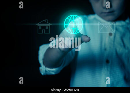 Détail de la main d'un enfant, d'appuyer sur le bouton allumé en bleu, avec le world wide web icône sur un écran virtuel. Photo montrant le concept de Banque D'Images