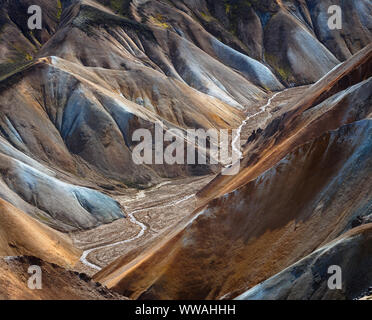 Le long d'une rivière dans la vallée entre les montagnes colorées de Landmannalaugar, Islande Banque D'Images