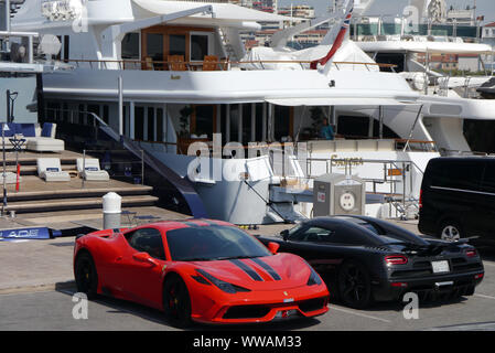 Sports voitures garées par bateau Yacht sur la jetée dans le port de Cannes, Côte d'Azur, France, Union européenne. Banque D'Images