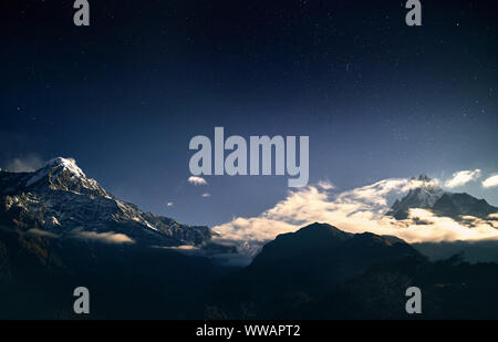 Montagnes enneigées et de l'Annapurna Machapuchare la nuit ciel étoilé au Népal Banque D'Images