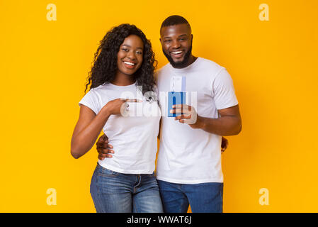 Happy young couple holding noire Passeports et billets Banque D'Images