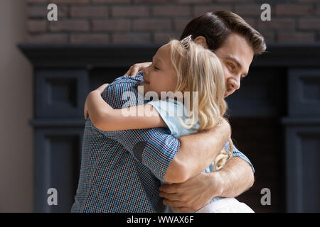 Heureux adorable preschool fille blonde de câliner young smiling père. Banque D'Images