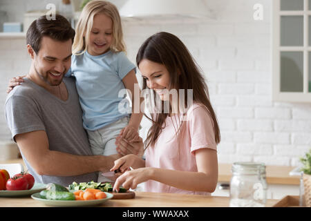 Beau jeune fille père tient, regarder la cuisine de maman. Banque D'Images