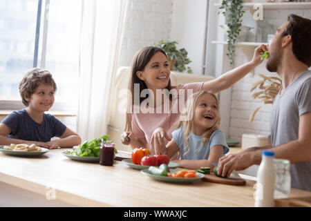 Head shot happy family sitting complet à l'occasion d'un grand table de cuisine. Banque D'Images