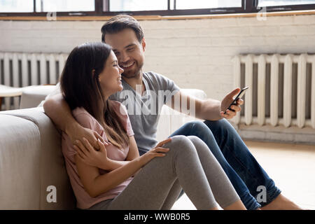 Deux jeunes mariés d'amour chaud assis sur un plancher en bois. Banque D'Images
