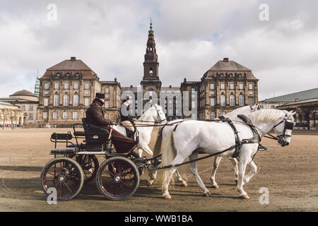 20 février 2019. Un officier militaire entraîne deux chevaux blancs des écuries royales devant. Chevaux et voiturette avec cavalier au palais de Christianborg. Royal Banque D'Images