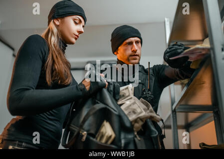 Voleurs en uniforme noir vole de l'argent depuis vault Banque D'Images