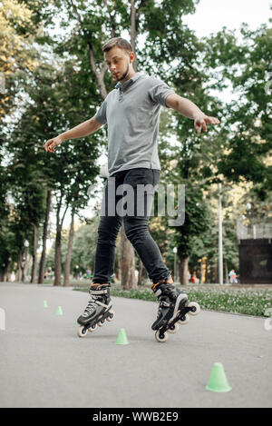 Le roller skater, autour des cônes de roulement Banque D'Images