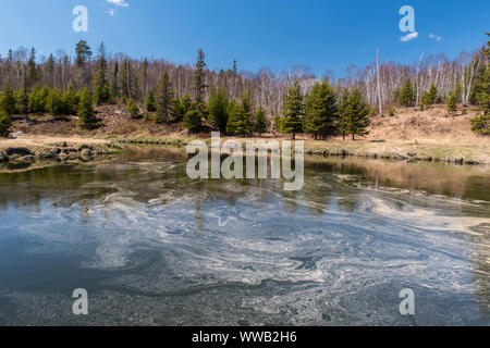 Le ruisseau Junction au début du printemps avec des tourbillons d'écume et de pollen flottant, le Grand Sudbury, Ontario, Canada Banque D'Images