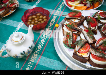 Pique-nique en plein air, des sandwiches avec des œufs, de la tomate et anchois, olives et tea pot, selective focus Banque D'Images