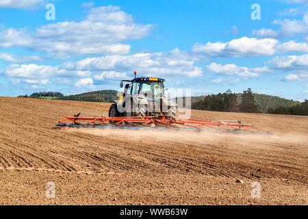 Un tracteur bleu sème le grain. Travail agricole sur une ferme de la République tchèque. Le tracteur sur un champ de blé. Les machines agricoles. Banque D'Images