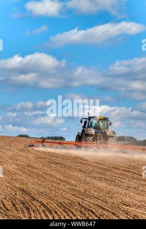 Un tracteur bleu sème le grain. Travail agricole sur une ferme de la République tchèque. Le tracteur sur un champ de blé. Les machines agricoles. Banque D'Images