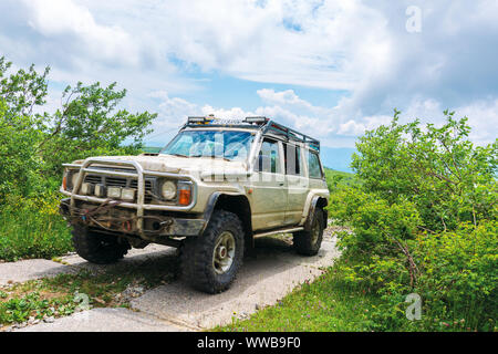 Mnt. Runa, Ukraine - JUN 19, 2019 : ancien véhicule hors route sur la montagne route pavée. sale SUV préparé pour la bataille avec la nature. Mountain dans le dis Banque D'Images