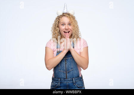 Cheerful woman with curly excité funny corne de licorne hurlant de plaisir et d'excitation, obtenir une excellente nouvelle. Banque D'Images