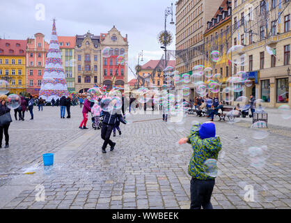 Wroclaw, Pologne le 17 novembre 2017. Les enfants courir après les bulles de savon dans la place principale de la ville, toutes décorées au cours de l'assemblée annuelle du marché de l'Avent Banque D'Images
