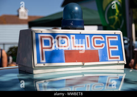 Une voiture de police vintage britannique signe et la lumière bleue sur le dessus d'une voiture de police Banque D'Images