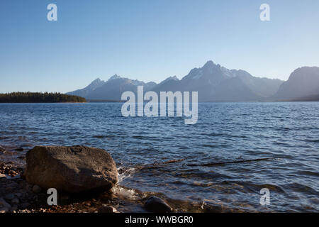 Coucher du soleil voilé derrière le Teton Mountains, à Jackson Lake à Grand Teton National Park Banque D'Images