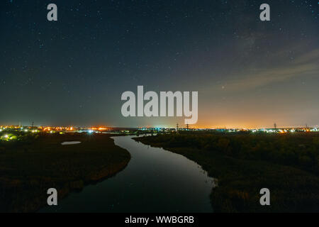 Une rivière menant à la nuit ciel étoilé. Nuit paysage rural Banque D'Images