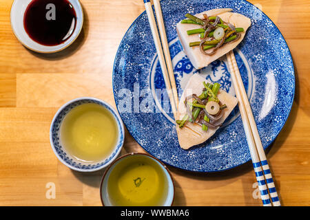 La plaque traditionnelle japonaise sur table en bois avec des légumes de printemps takenoko de pousses de bambou, sansai d'herbes sauvages avec des baguettes, je Thé vert sencha Banque D'Images