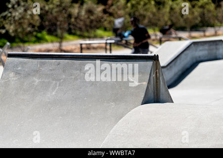 Quatrième Ward outdoor skate park à Atlanta, Géorgie le centre-ville de ville avec jeune homme de patinoires et de l'extérieur en faisant stunt trick arrière-plan flou Banque D'Images