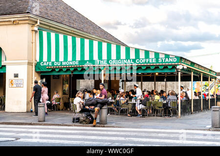 New Orleans, USA - 22 Avril 2018 : Les gens assis dehors au Café du Monde restaurant, manger beignet beignets de sucre en poudre, de boire un café de chicorée Banque D'Images