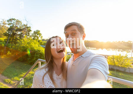 La Capture de moments lumineux. Jeune couple aimant joyeux drôle de caméra alors que sur selfies standing outdoors Banque D'Images