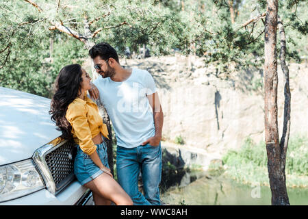 Homme barbu à lunettes debout avec la main dans la poche et à la fille à Banque D'Images