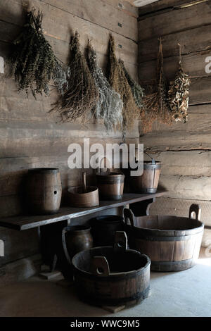 Intérieur du chalet en bois ancien couloir avec fleurs séchées et d'herbes, pots, seaux et barils éclairées par le soleil du matin. Polish still life. Banque D'Images