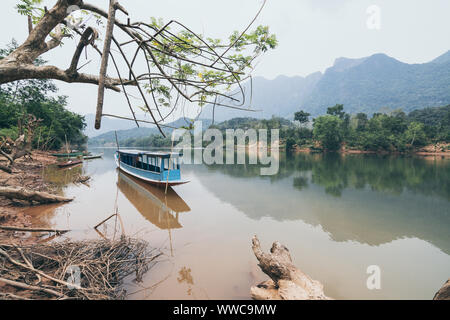 En laotien traditionnel bateau lent sur la rivière Nam Ou près du village de Nong Khiaw, Laos. Reflet dans l'eau Banque D'Images