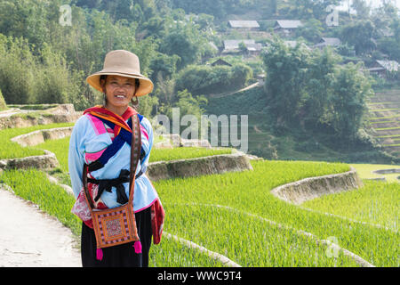 Sapa, Vietnam - Mai 2019 : femme de l'ethnie hmong en costume traditionnel marche à côté de la terrasse de riz dans la province de Lao Cai Banque D'Images