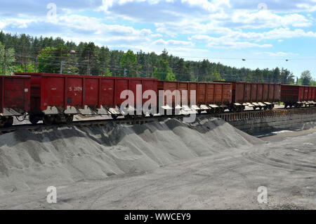 Le déchargement des wagons de chemins de pierre concassée. Le déchargement des cargaisons en vrac de wagons de chemin de fer sur une plate-forme. Travailler avec une cargaison en vrac. Banque D'Images